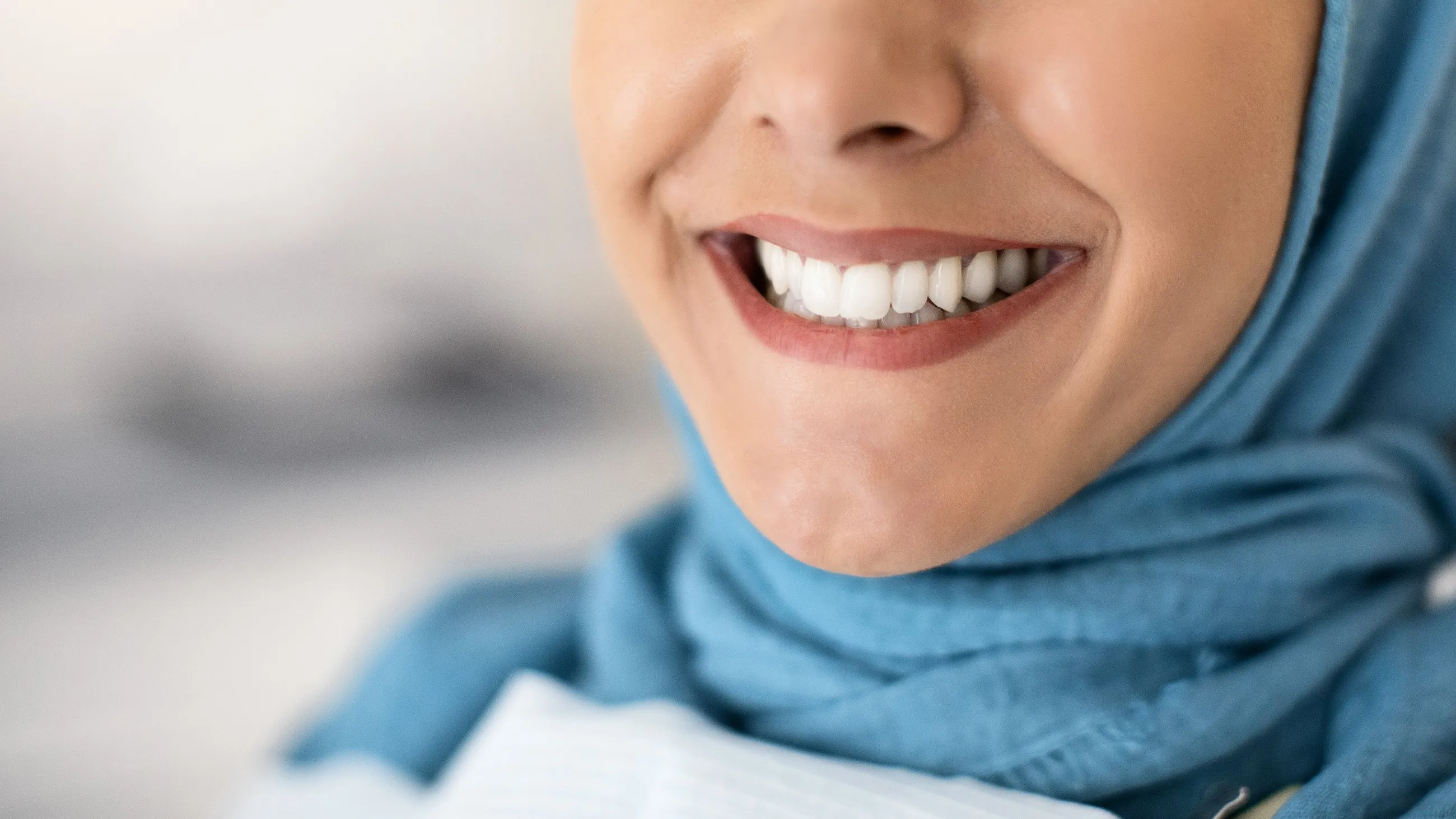 An adult woman smiling with healthy white teeth