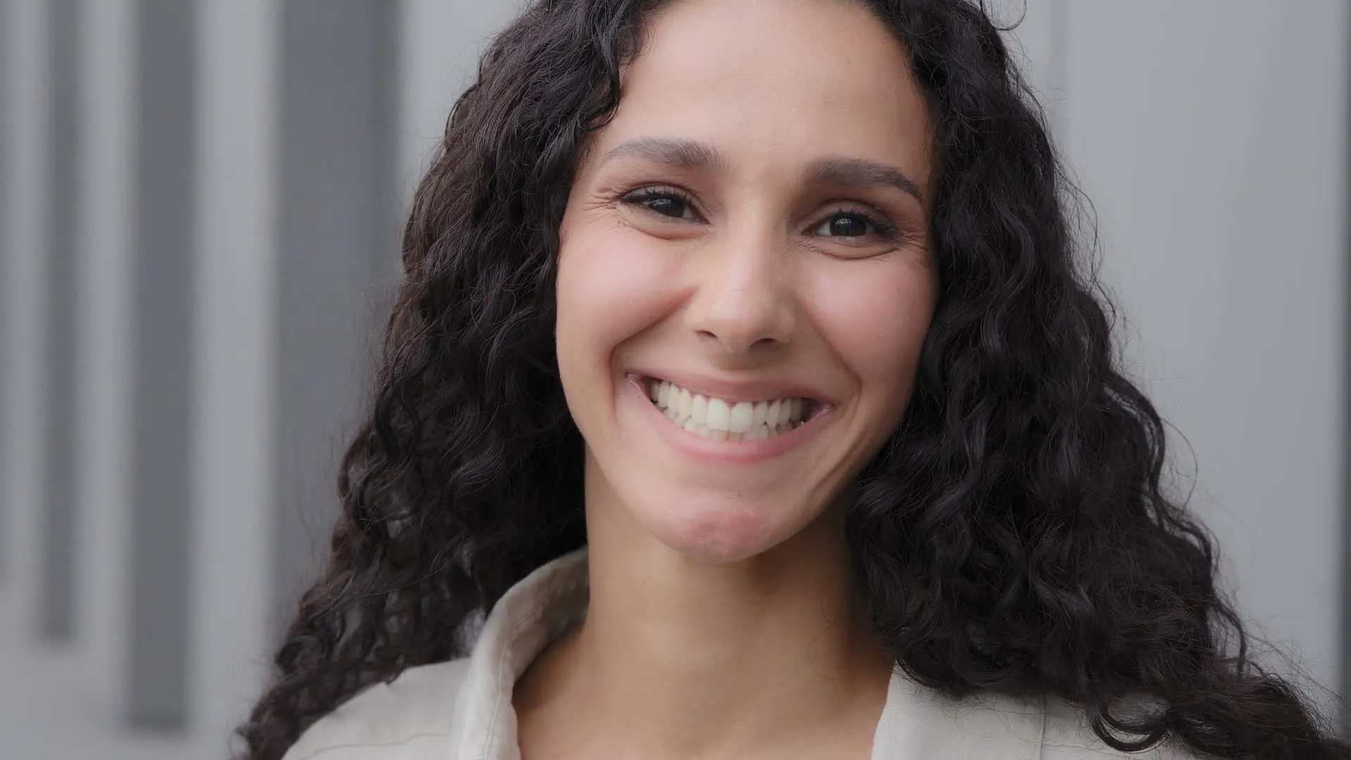 A woman smiling in bright daylight
