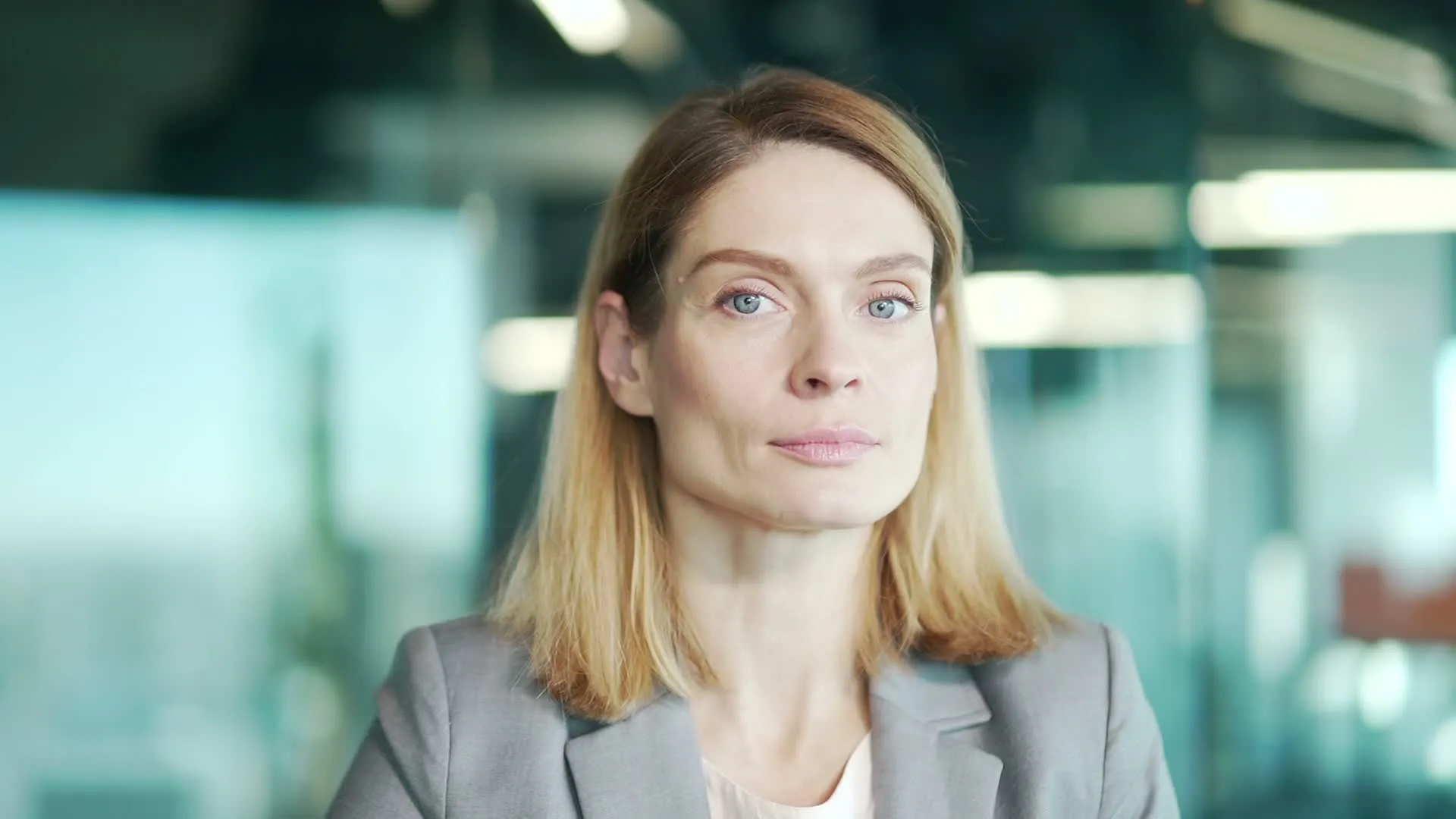A woman smiling in a grey suit