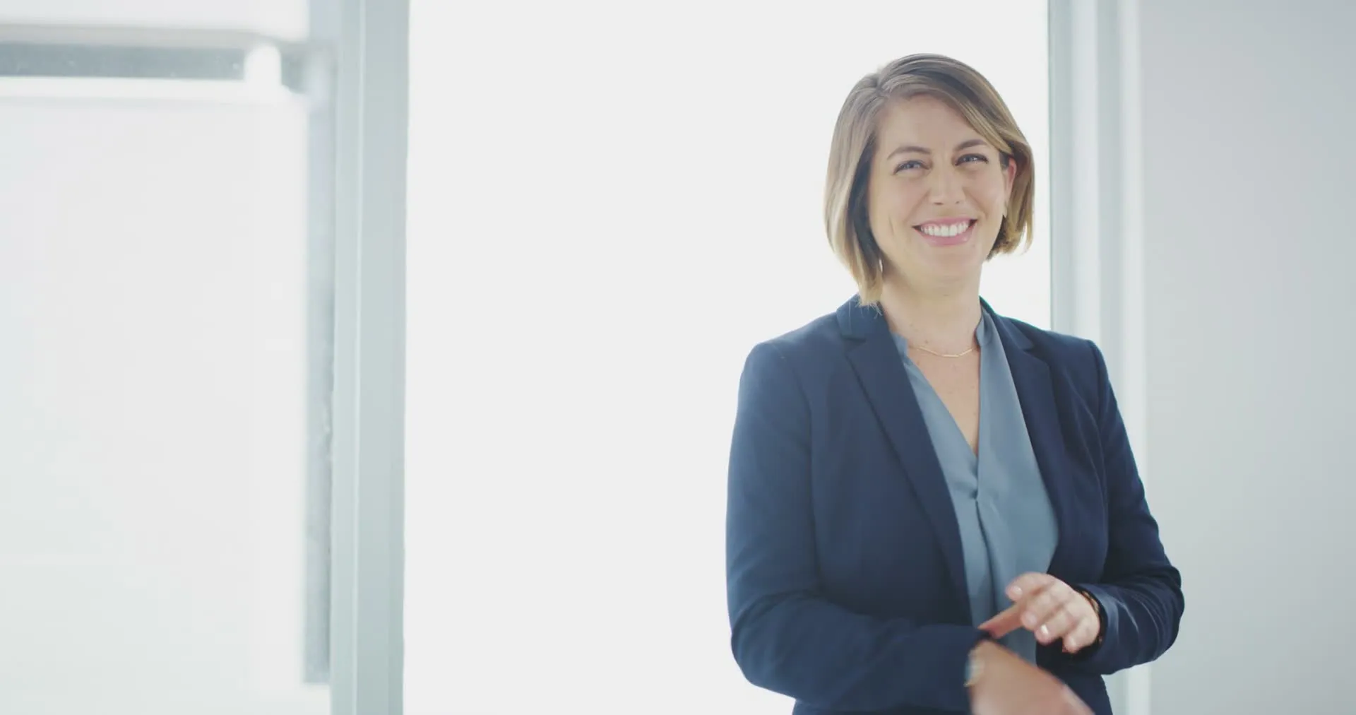 A smiling woman in a bright corporate office