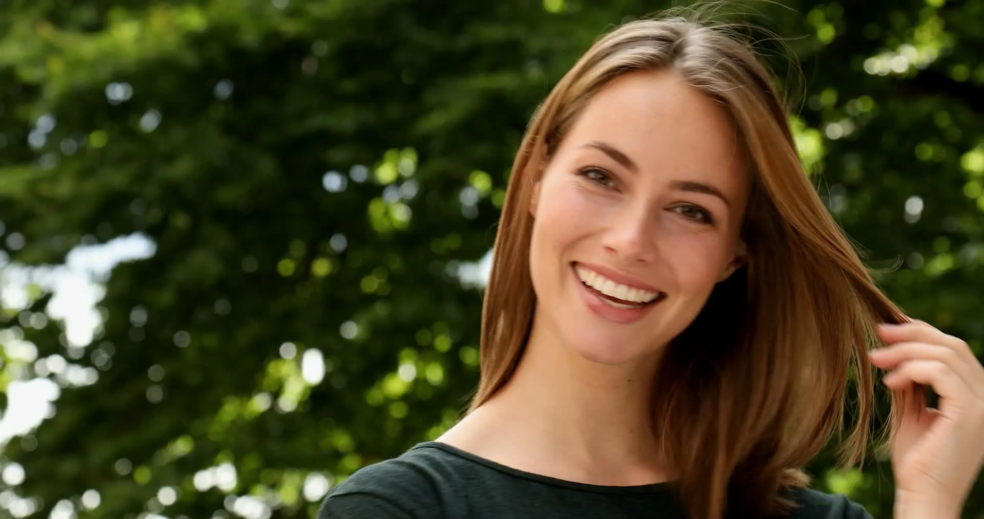 A woman smiling outdoors on a sunny day in Sarasota, Florida