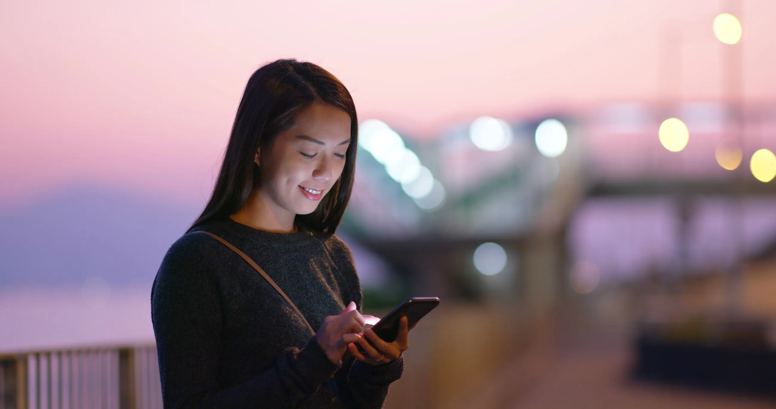 A woman smiling in the city at twilight
