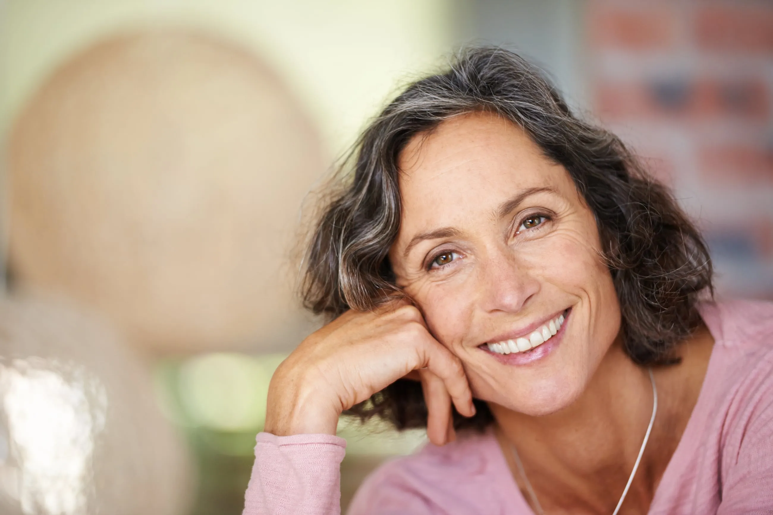 A woman smiling, resting her head on her hand, in Sarasota, Florida